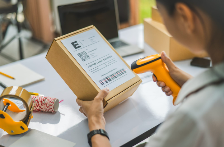 Un trabajador escaneando el código de barras de un paquete con un escáner de mano