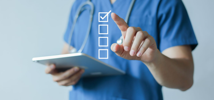 Mano de un médico de atención primaria utilizando un lápiz digital para marcar una lista de verificación médica